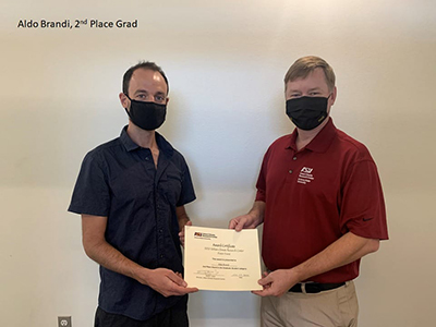 Two people wearing masks holding an award