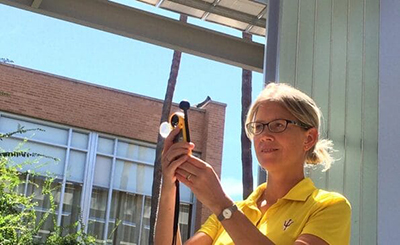 A blonde woman taking a picture outdoors